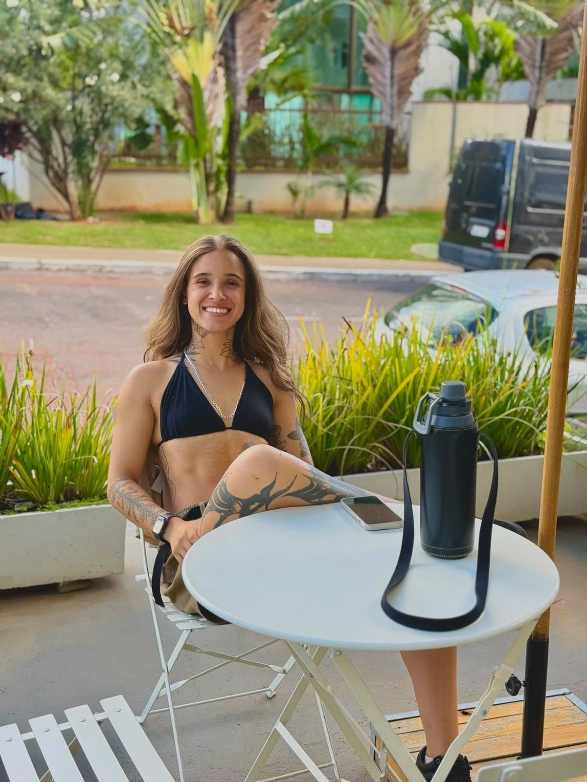Personal trainer conduzindo um alongamento assistido ao ar livre, luz natural